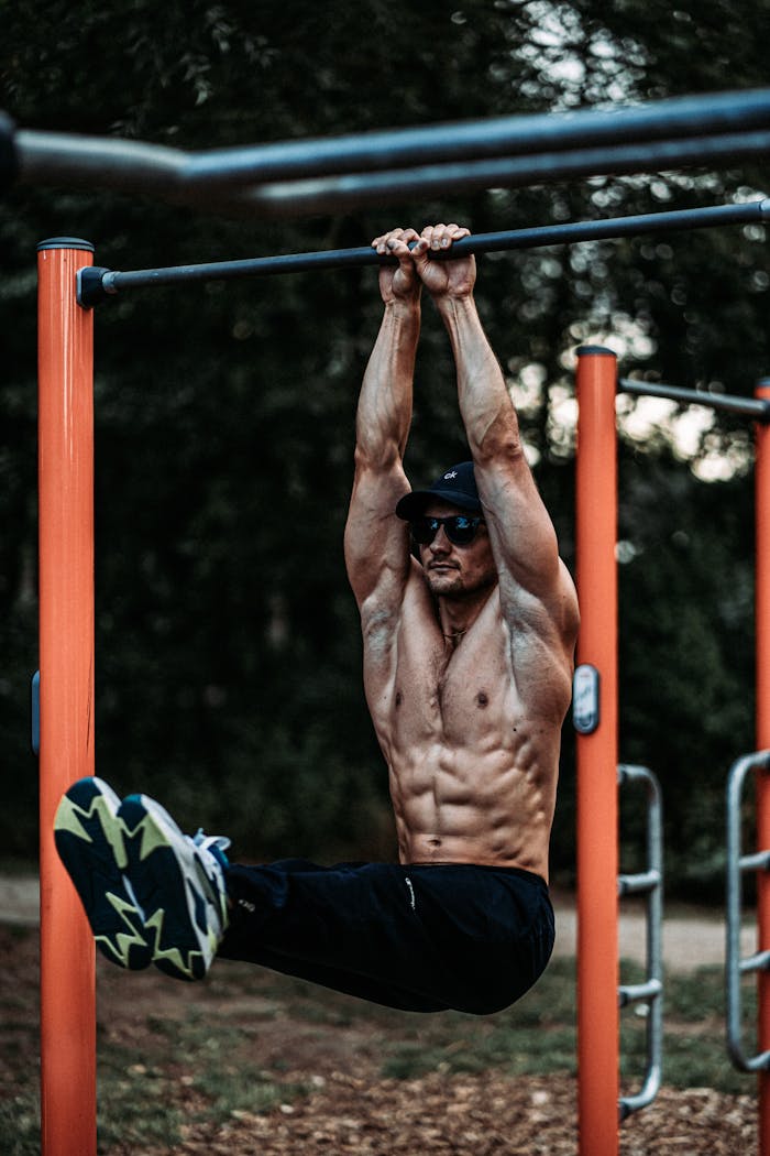 Home An athletic man exercising on a horizontal bar outdoors, showcasing strength and fitness.